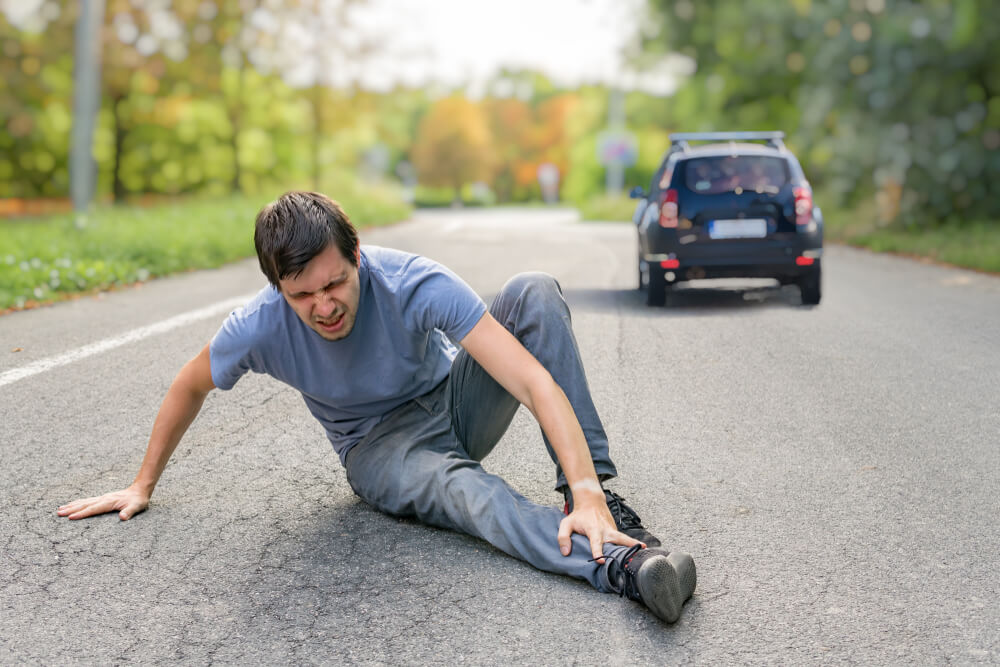 Injured pedestrian got hit and run by a car.