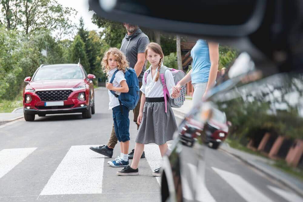 Cars stop while kids crossing the lane.