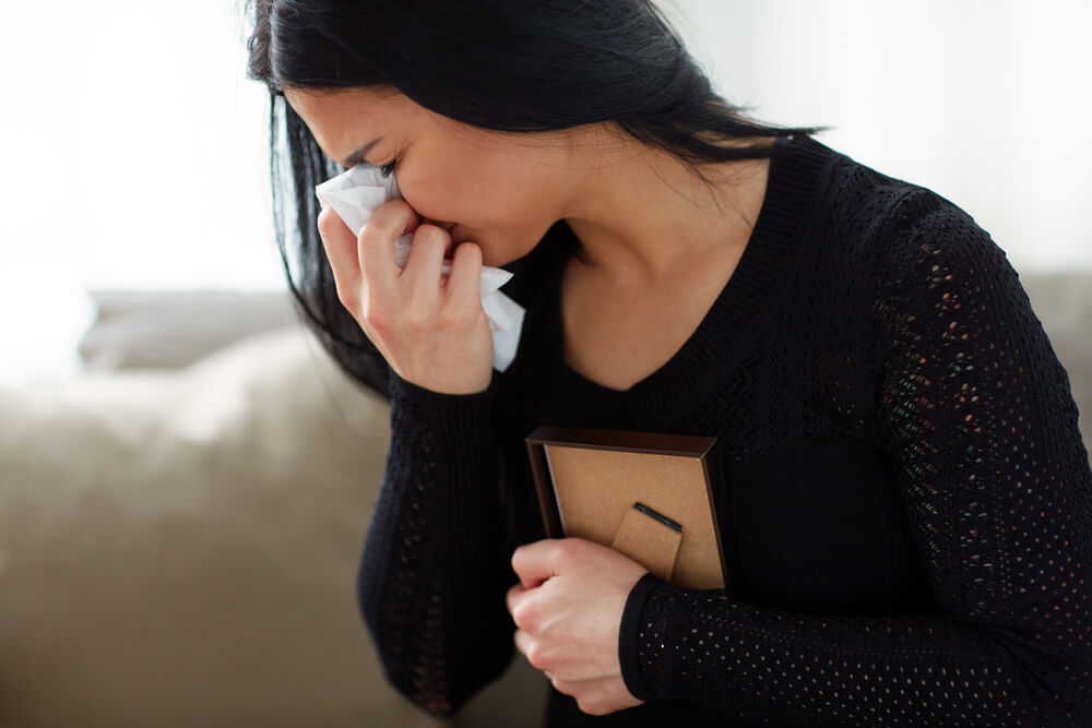 Widow crying on the loss of her late husband.