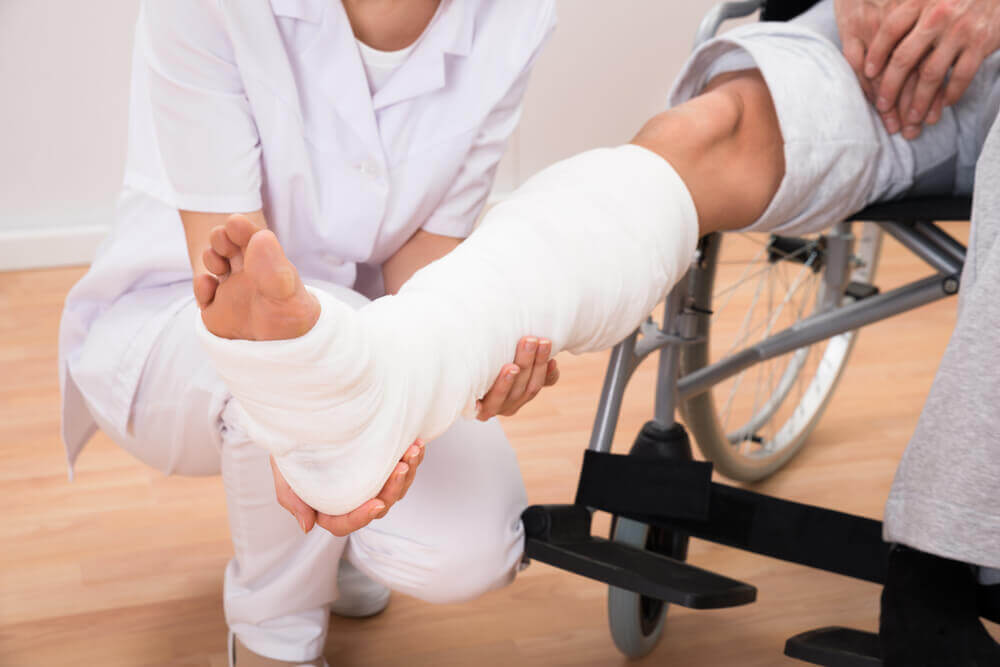 Man on wheelchair suffering broken leg from injury,