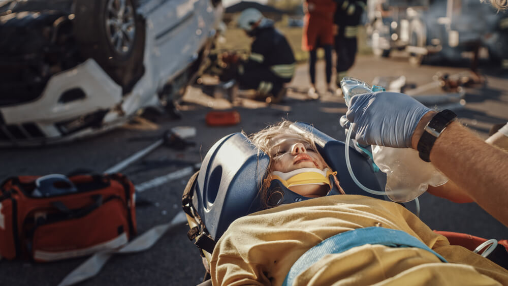 Paramedics rescuing patient from car accident suffering internal injuries.