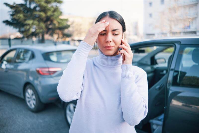 Lady driver in accident calling police to report.