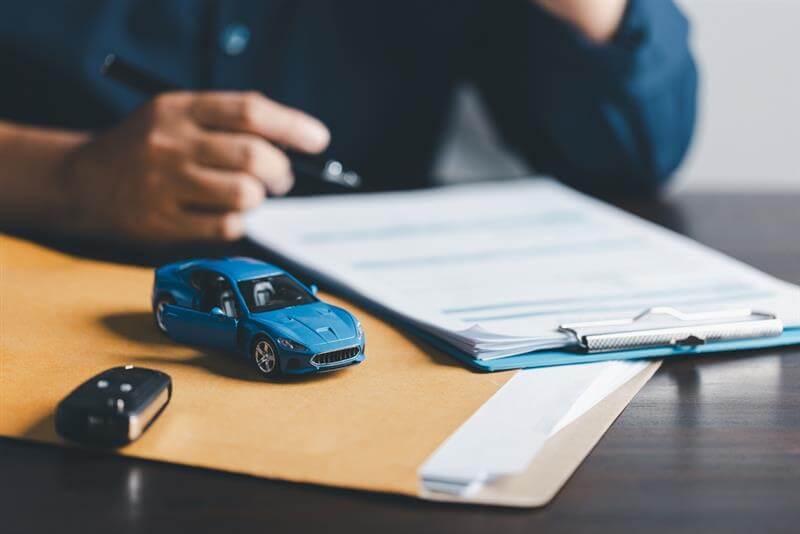 Man signing car insurance documents.