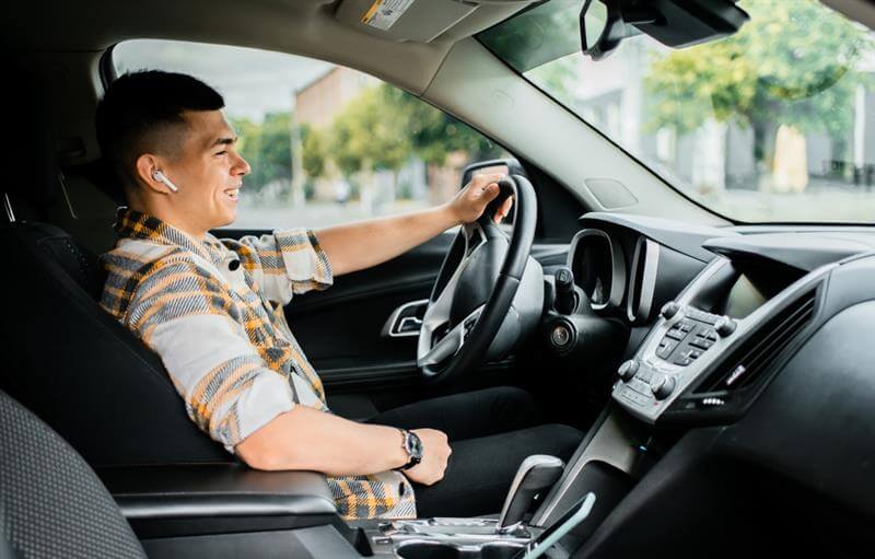 Man driving a car in a headset for talking.