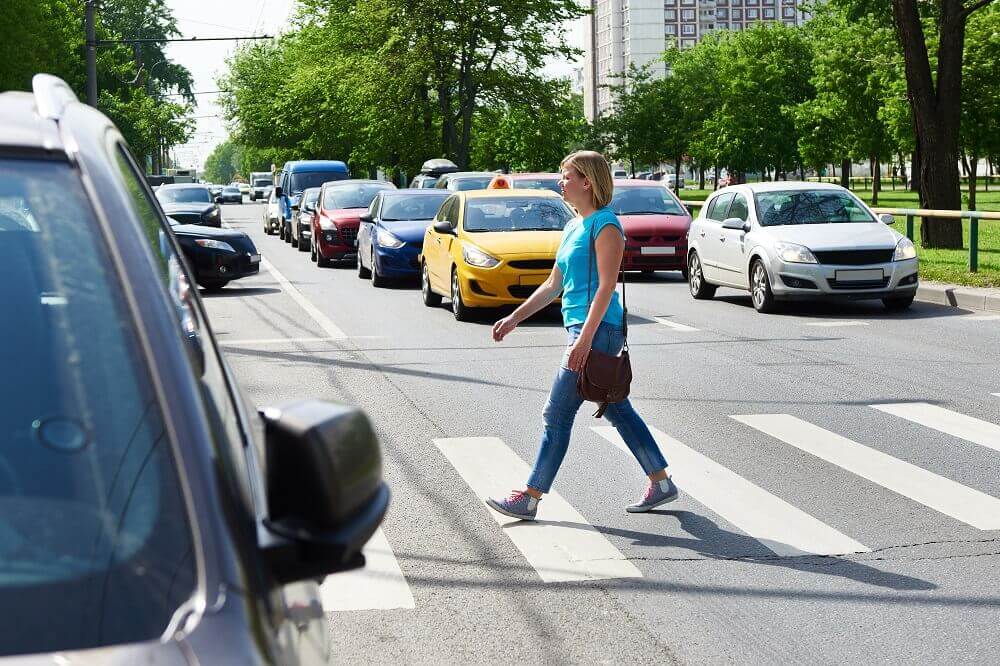 Lady pedestrian crossing the lane.
