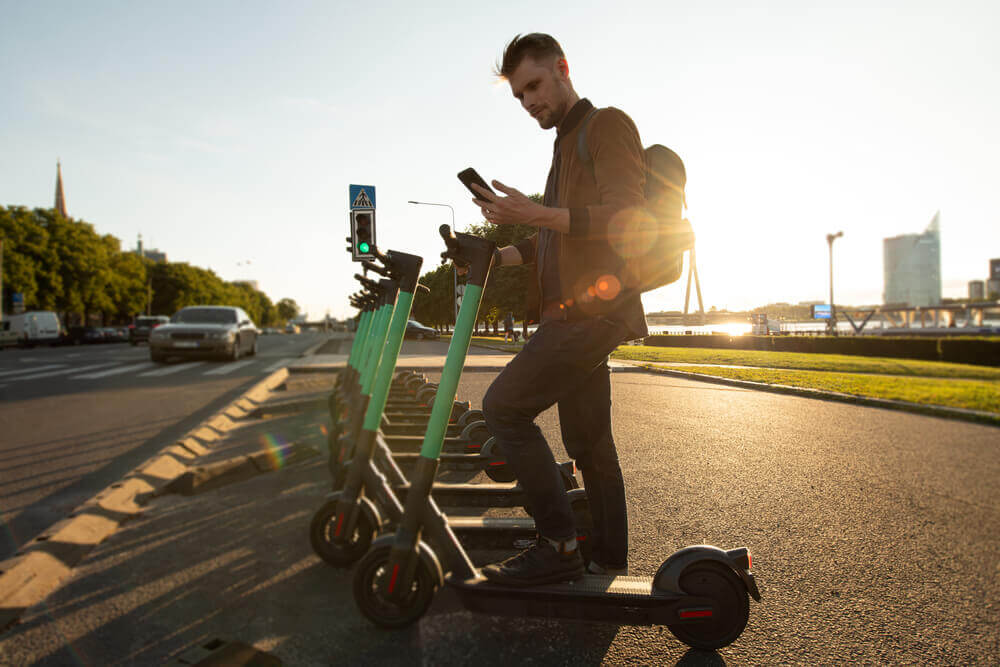 Man riding his e-scooter in the city street.