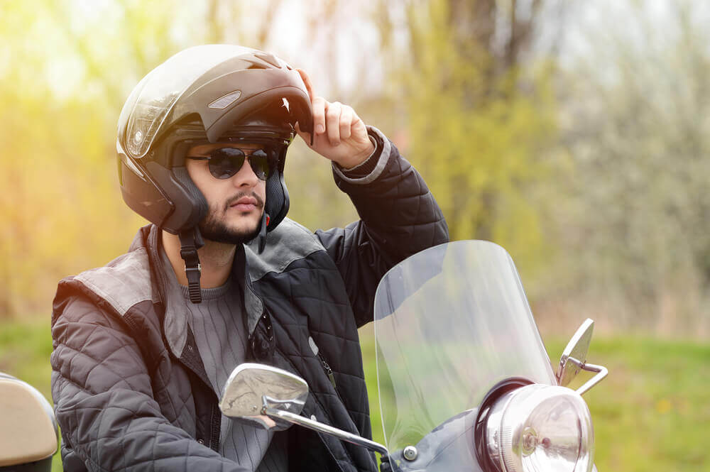 Motorcycle rider wearing helmet for safety.