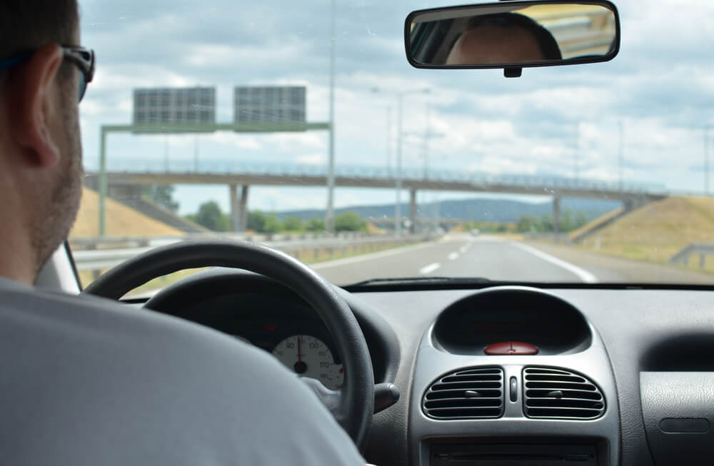 Man driving in wide angle view in interstate highway.